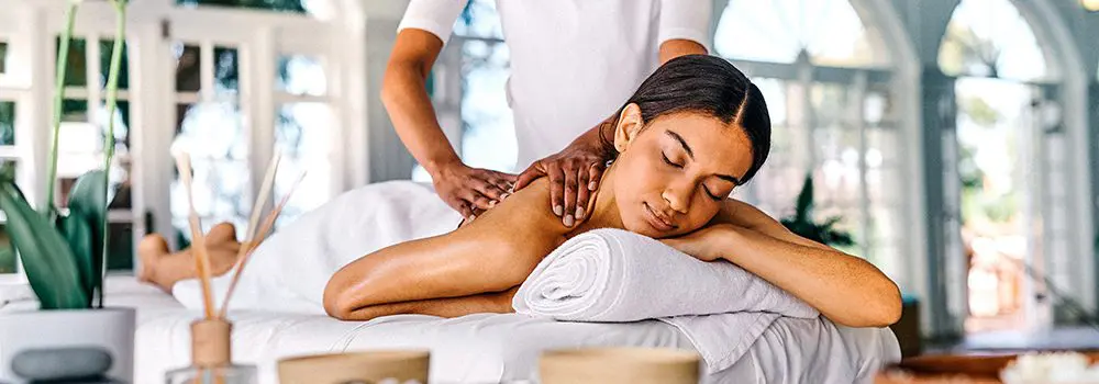 Shot of an attractive young woman lying on a bed and enjoying a massage at the spa